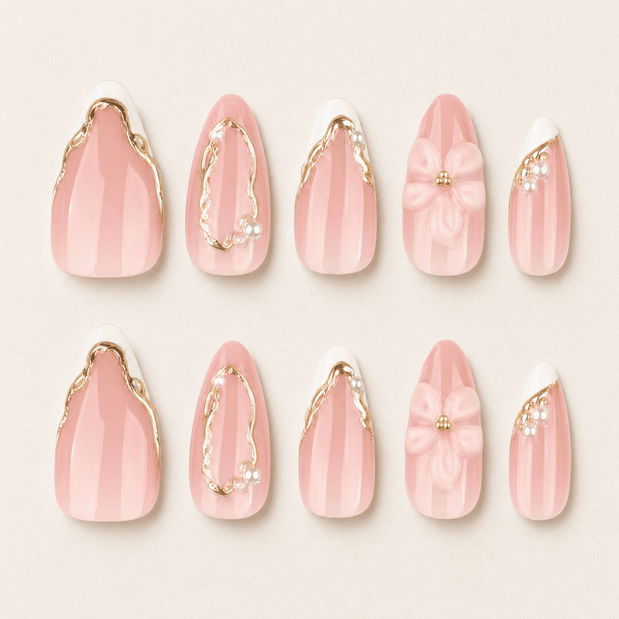 Blush-pink almond press-on nails with white flowers and gold details