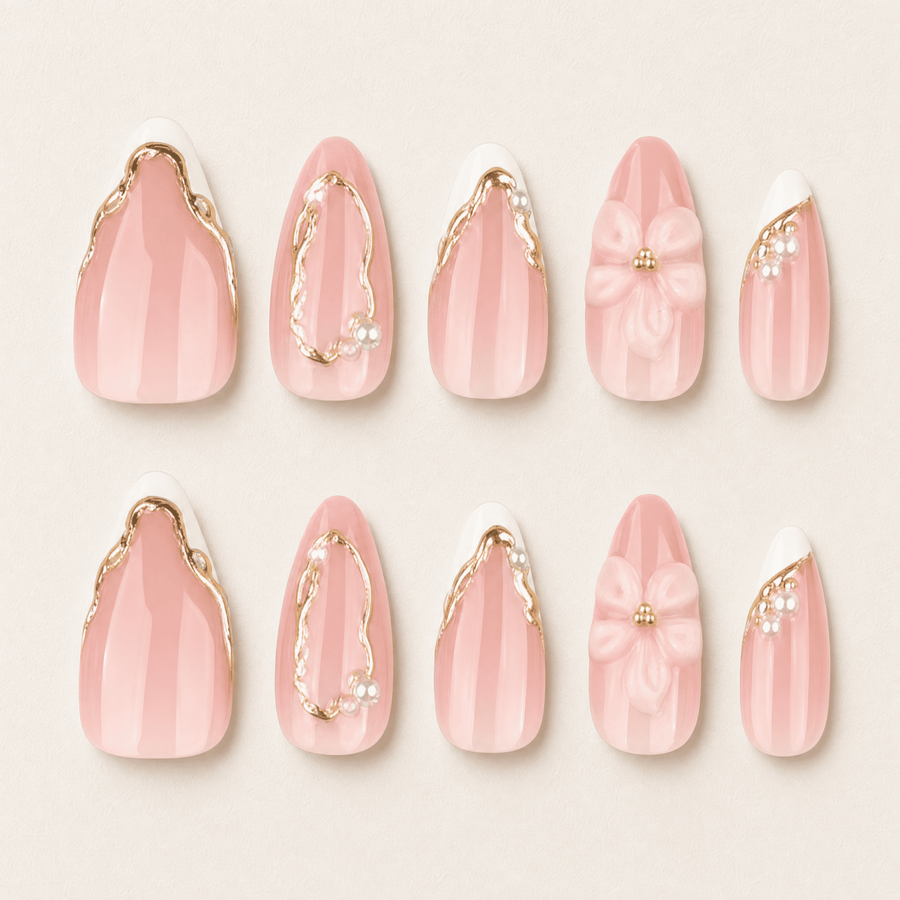 Blush-pink almond press-on nails with white flowers and gold details