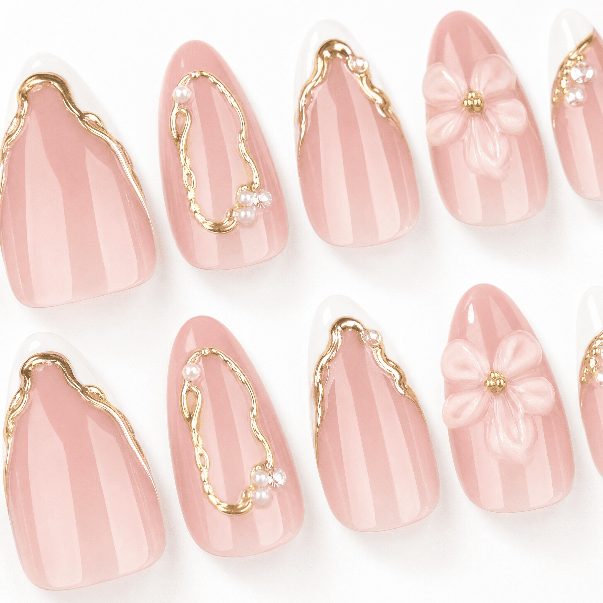 Blush-pink almond press-on nails with white flowers and gold details