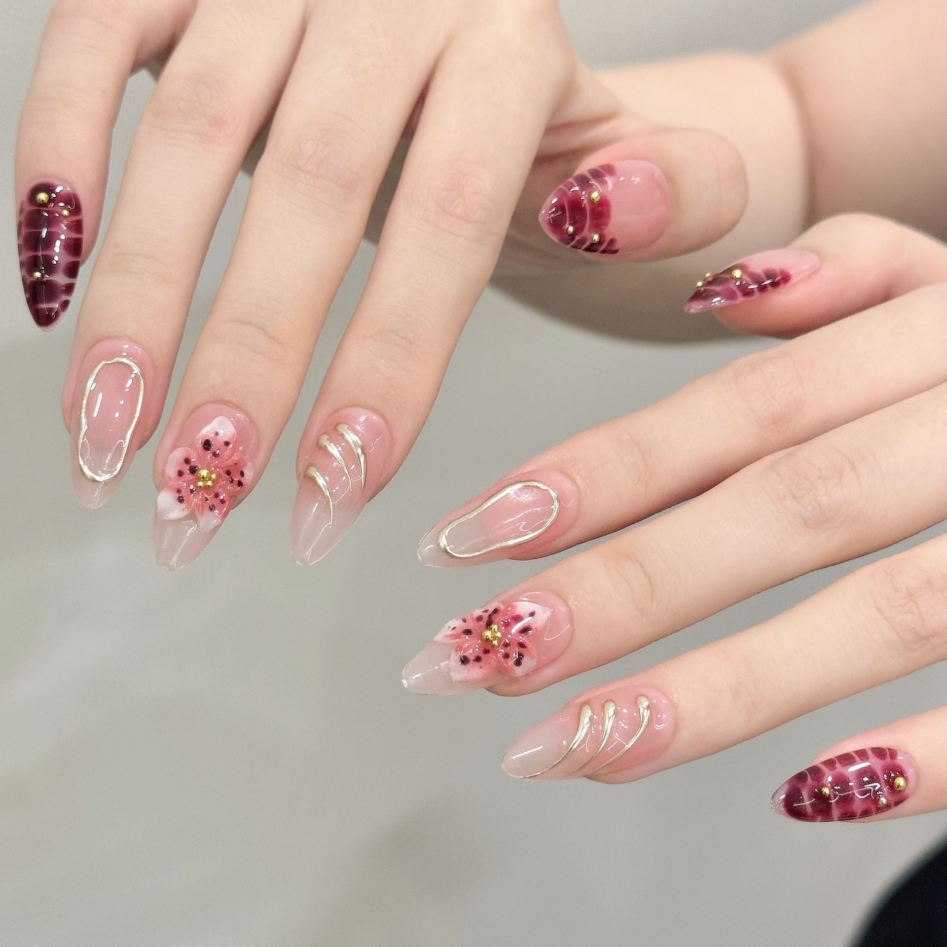 Burgundy floral almond press-on nails worn on one handburgundy-bloom-almond-press-on-nails-0