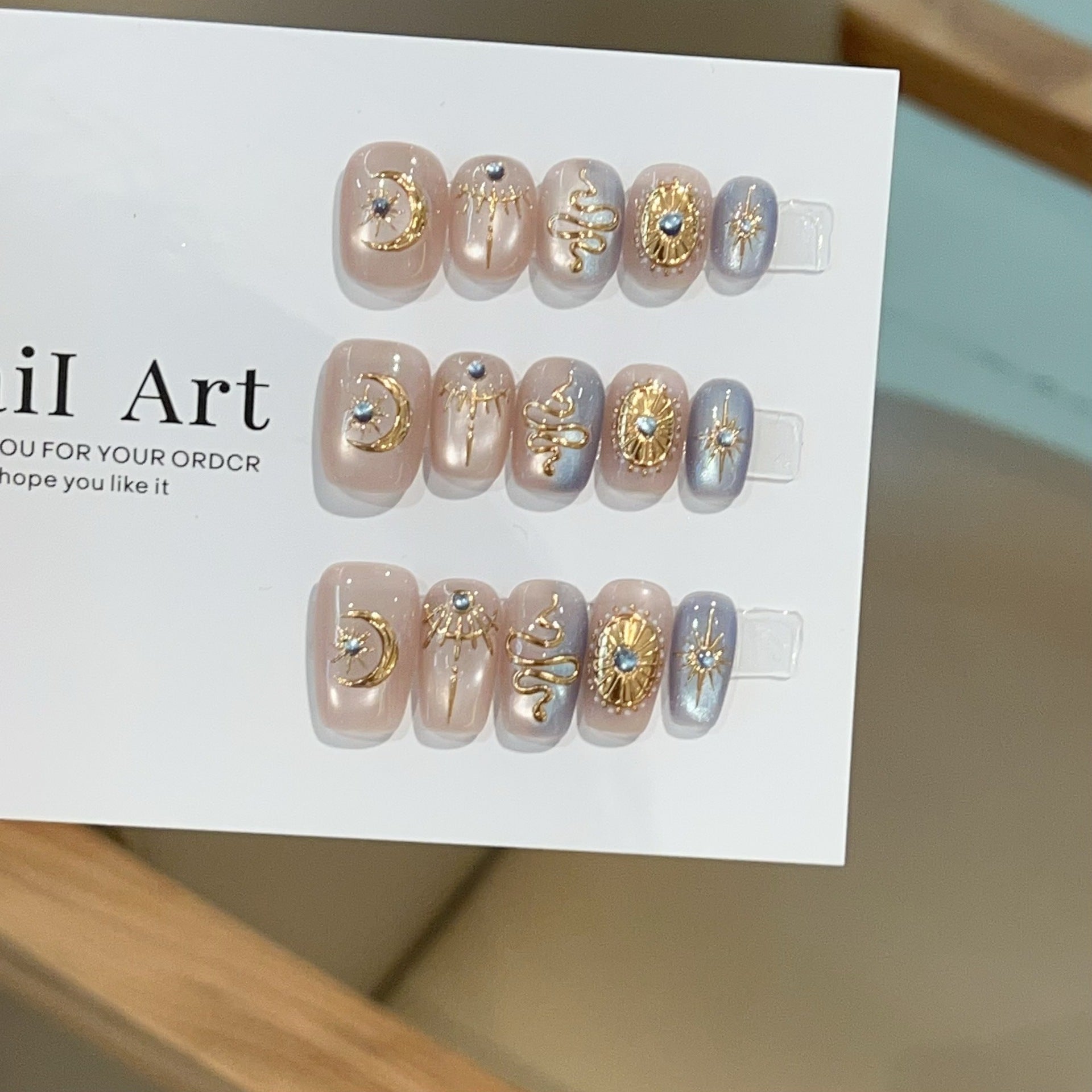 Celestial Baroque press-on nails with gold moon and serpent details