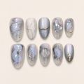 Icy blue and silver cat-eye press-on nails with gold accents
