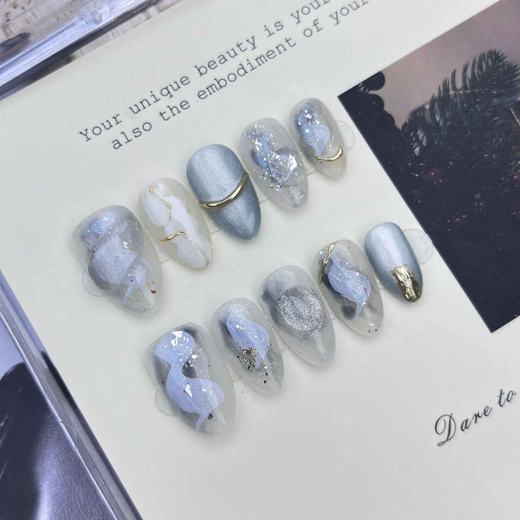 Icy blue and silver cat-eye press-on nails with gold accents