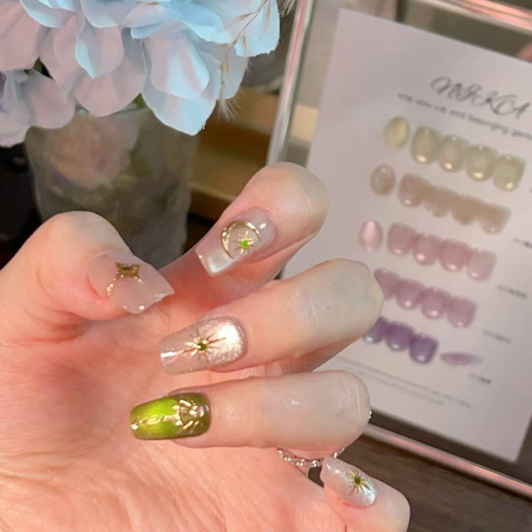 Green and gold short-square press-on nails with celestial designs