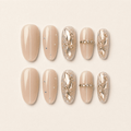 Nude oval cat-eye press-on nails with crystal and gold embellishments