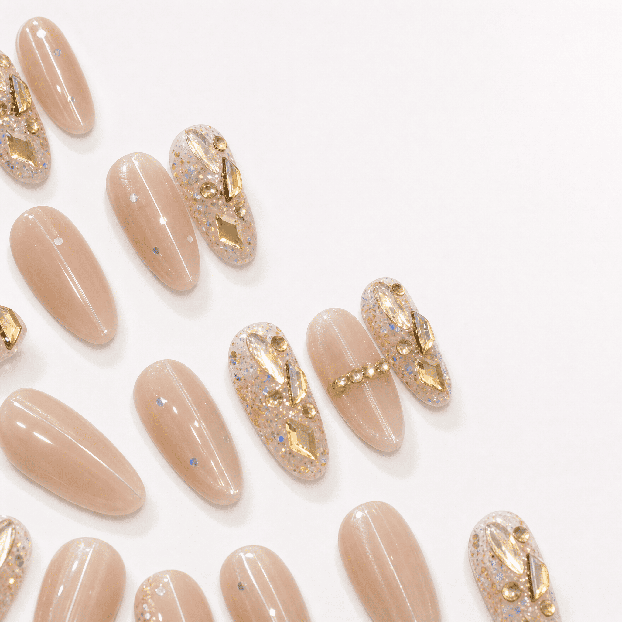 Nude oval cat-eye press-on nails with crystal and gold embellishments