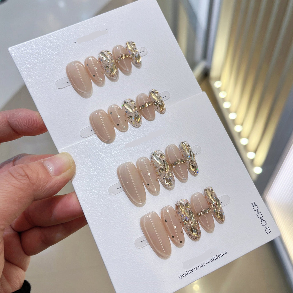 Nude oval cat-eye press-on nails with crystal and gold embellishments