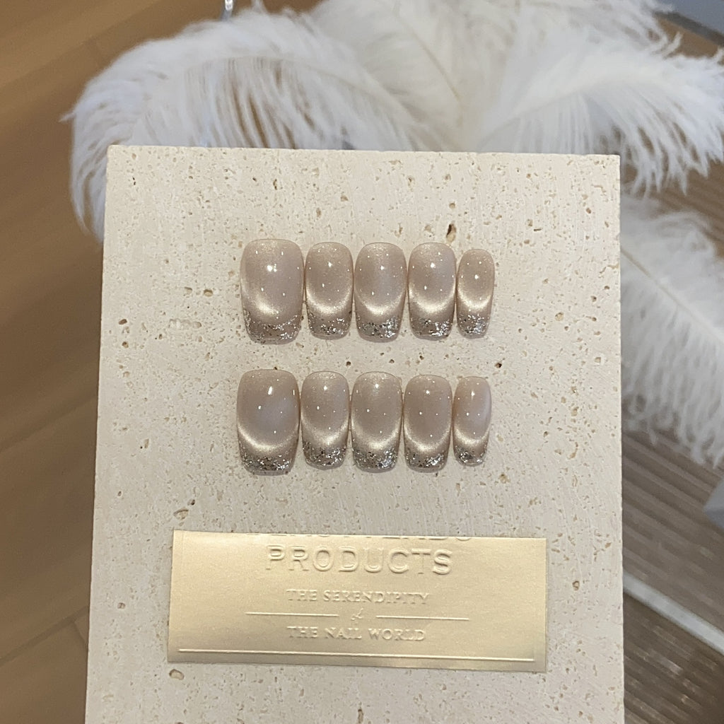 Champagne cat-eye press-on nails with silver glitter French tips