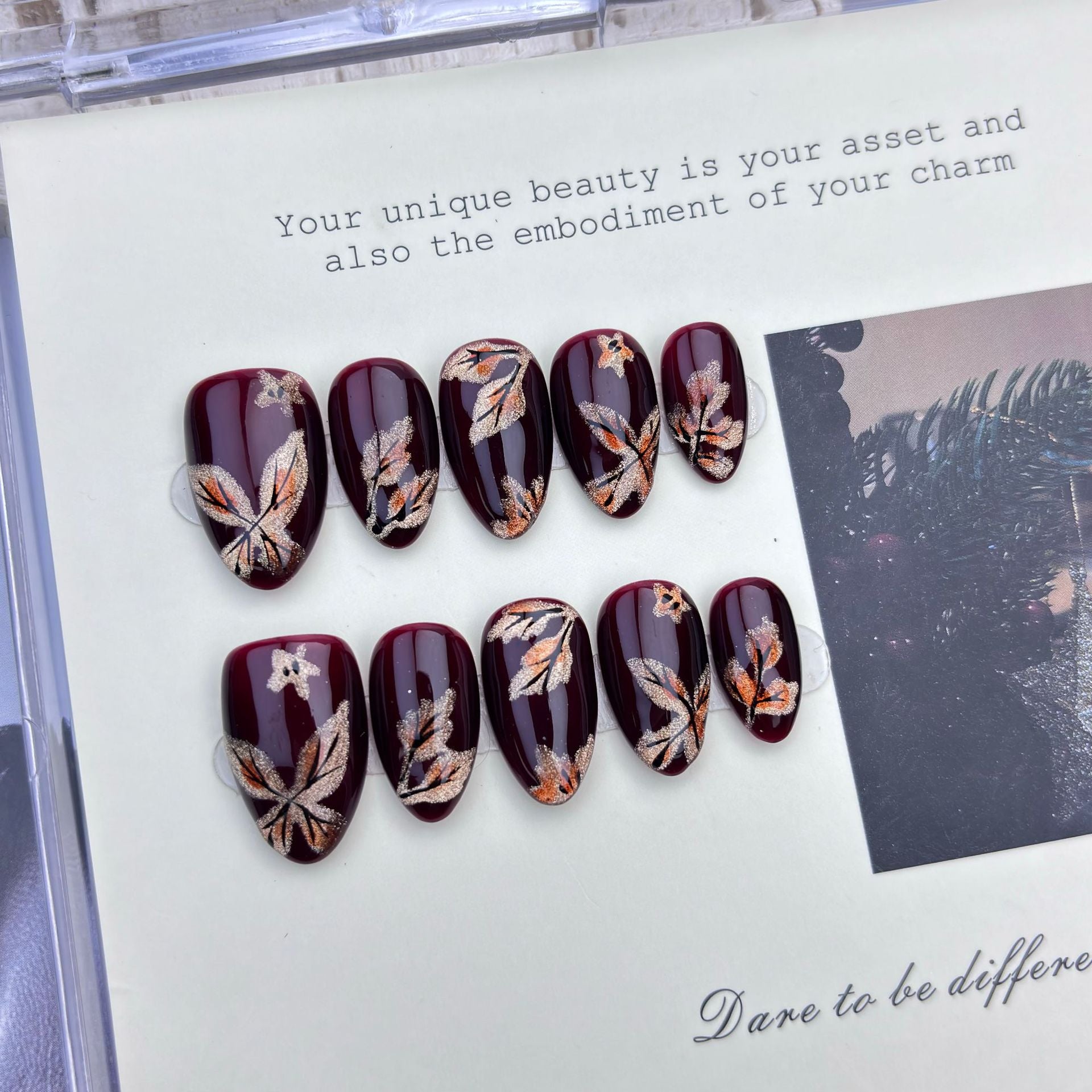 Burgundy short almond press-on nails with shimmering butterfly artwork