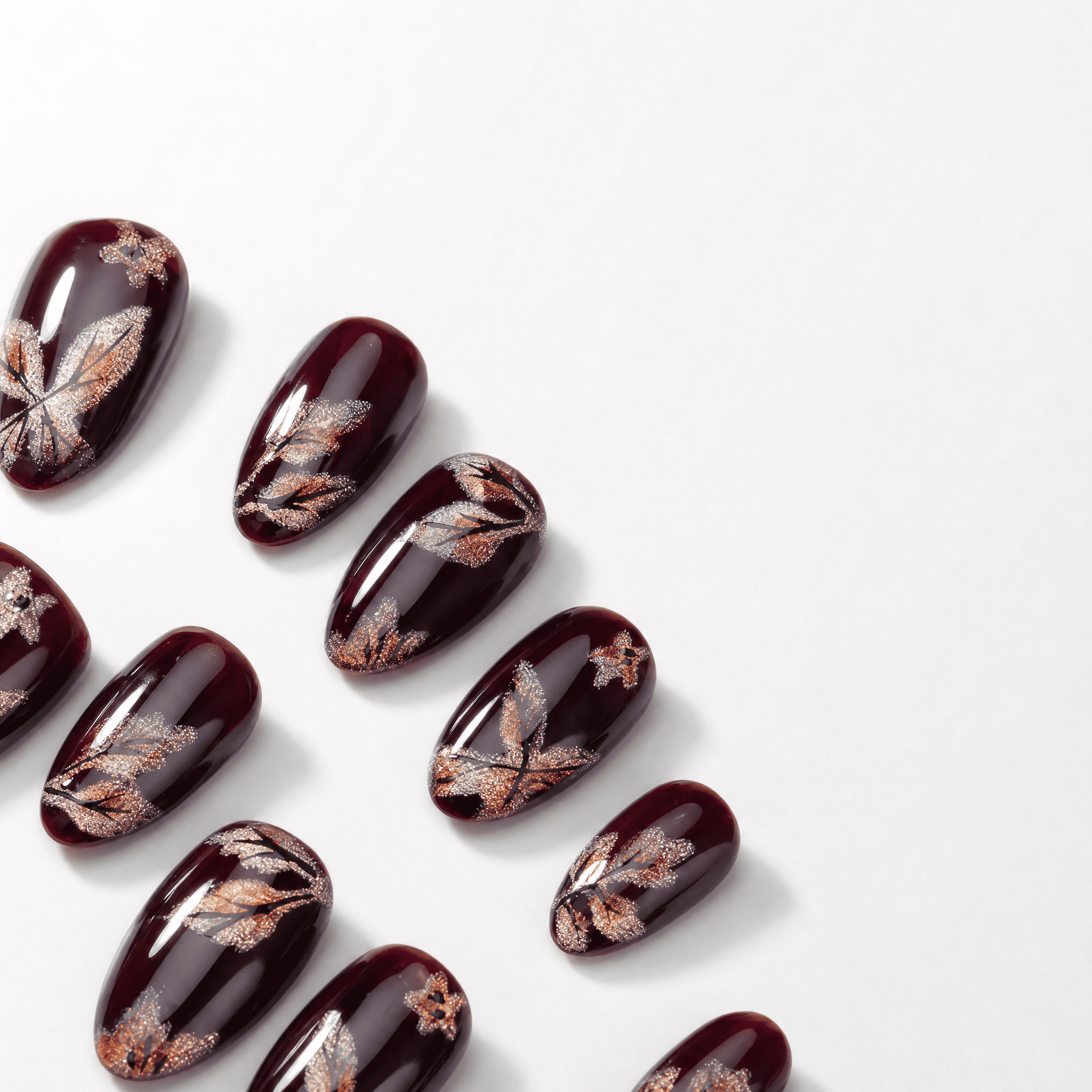 Burgundy short almond press-on nails with shimmering butterfly artwork