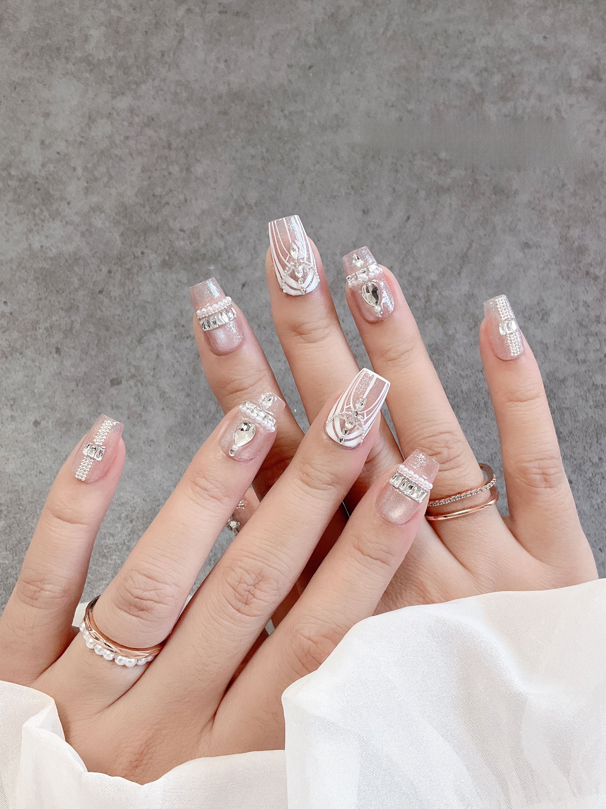 Blush crystal tapered-square press-on nails worn on both hands
