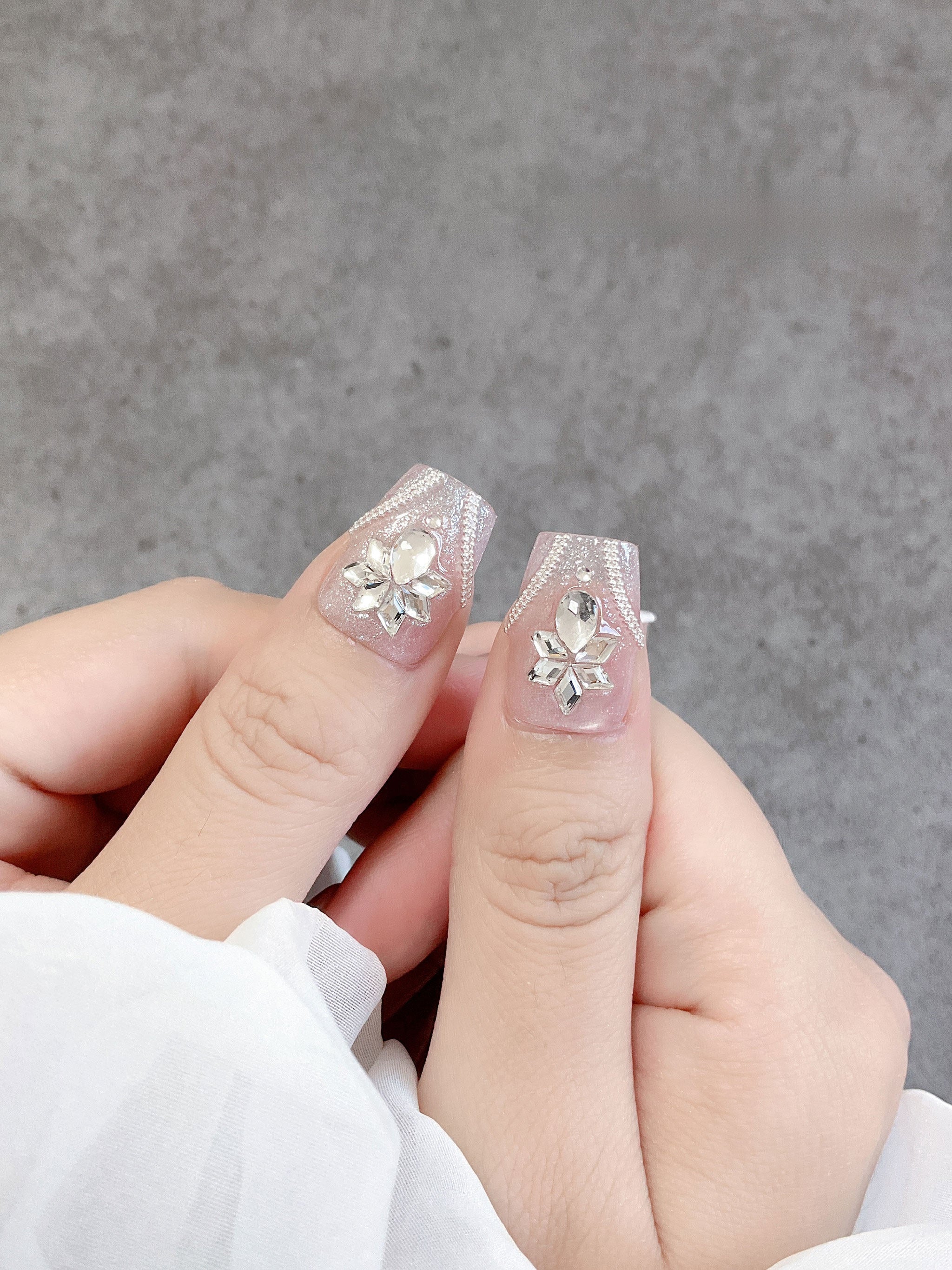 Blush crystal tapered-square press-on nails worn on both hands