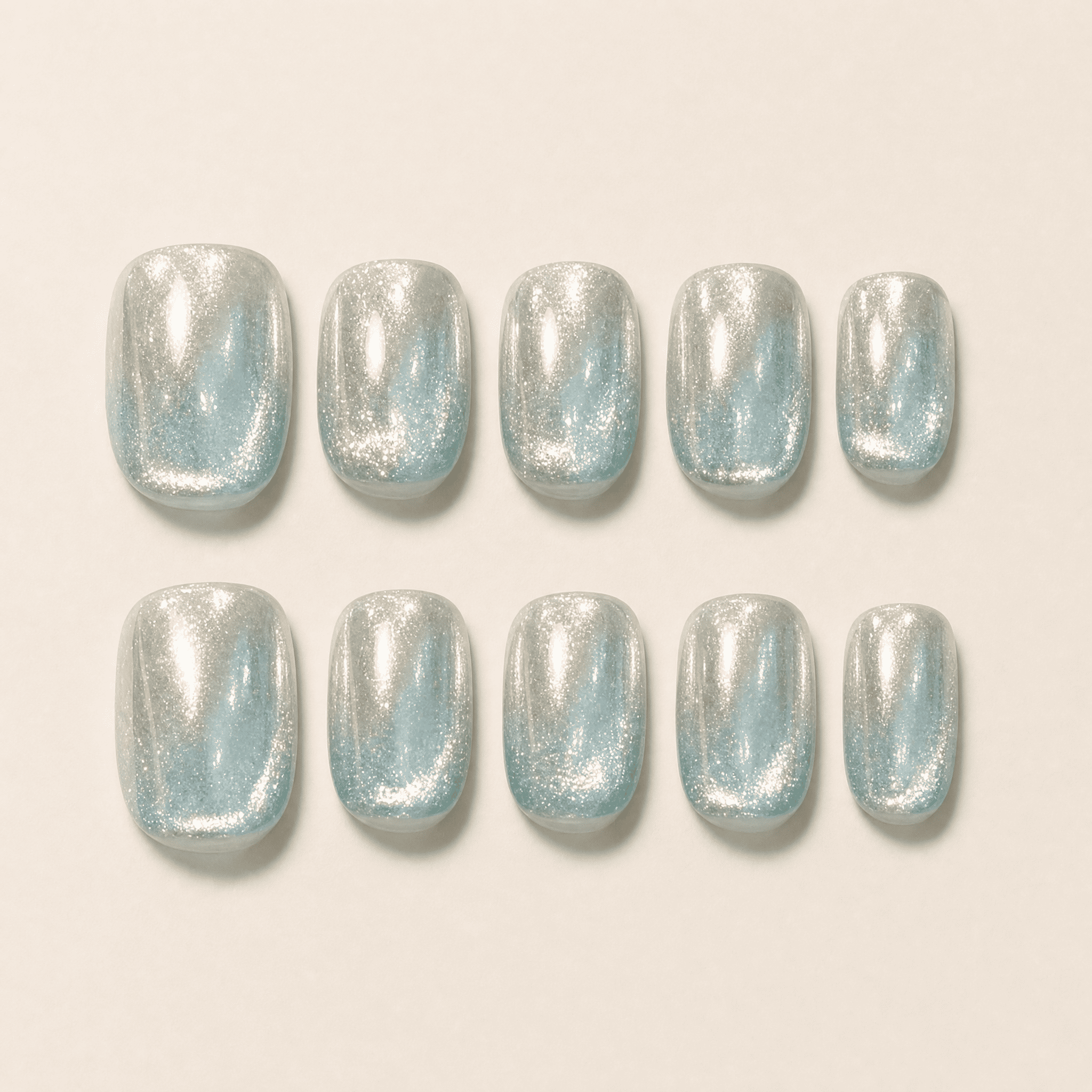 Icy-blue silver mirror cat-eye press-on nails worn on a hand