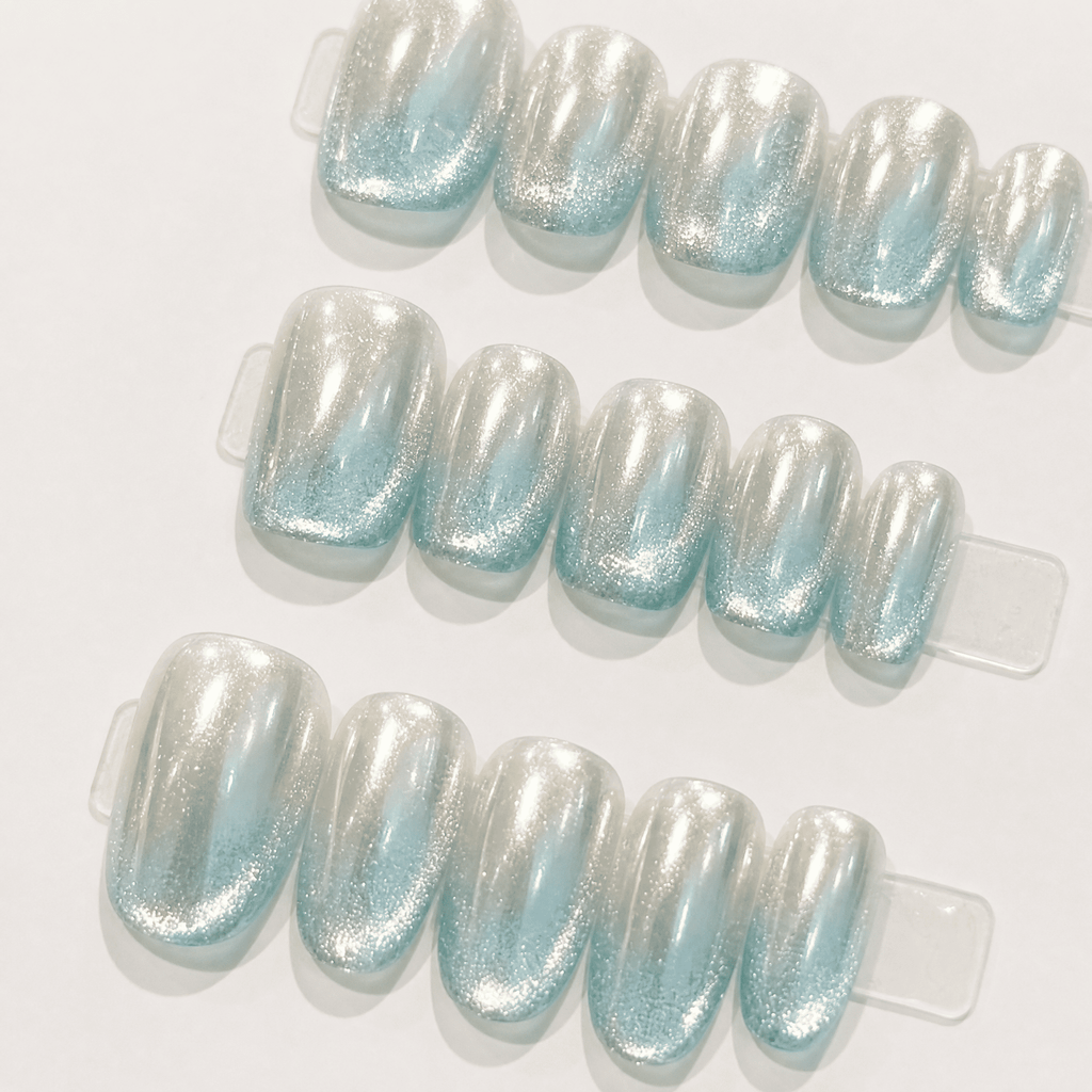 Icy-blue silver mirror cat-eye press-on nails worn on a hand
