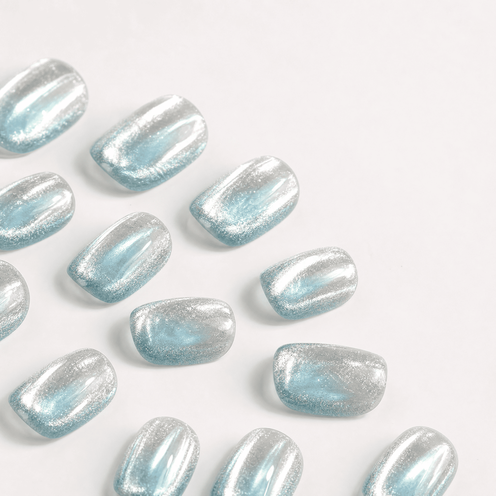 Icy-blue silver mirror cat-eye press-on nails worn on a hand