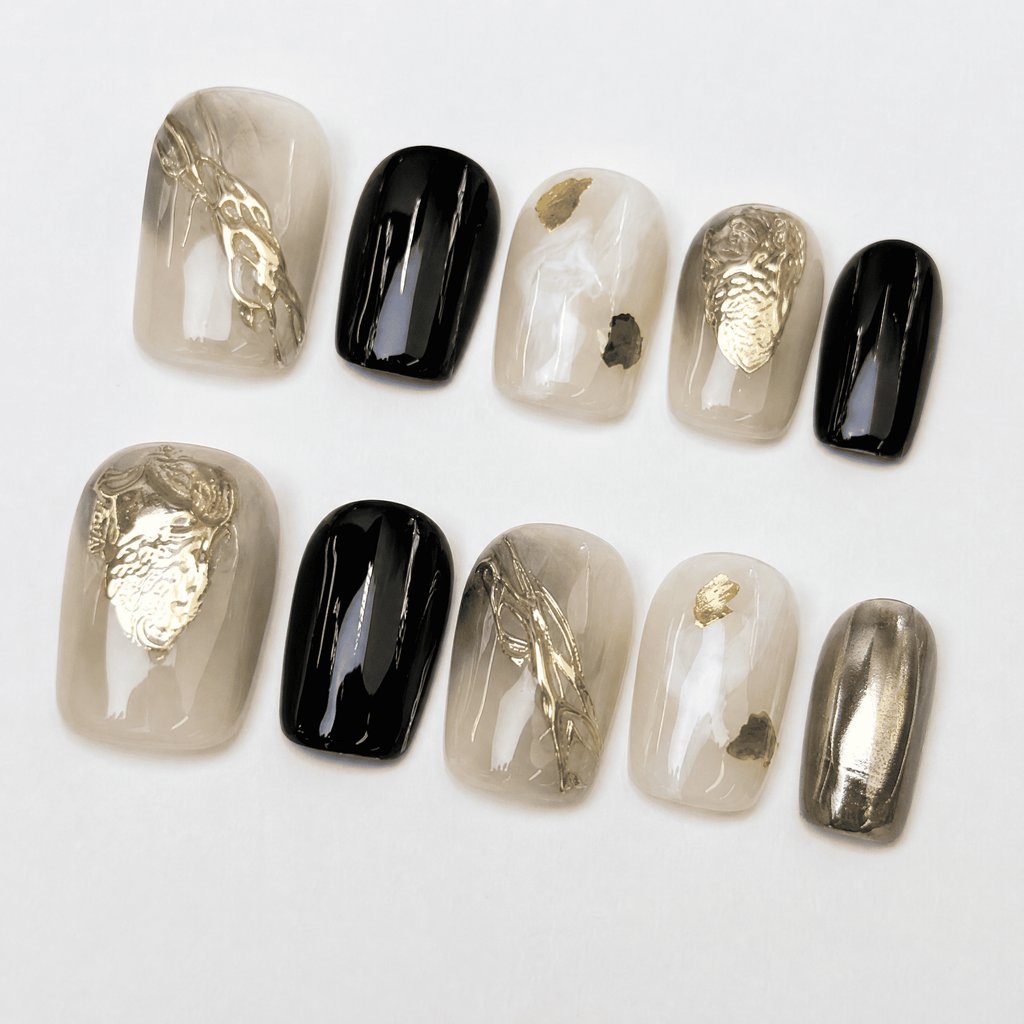 Black and gold short squoval press-on nails with smoky nude accents