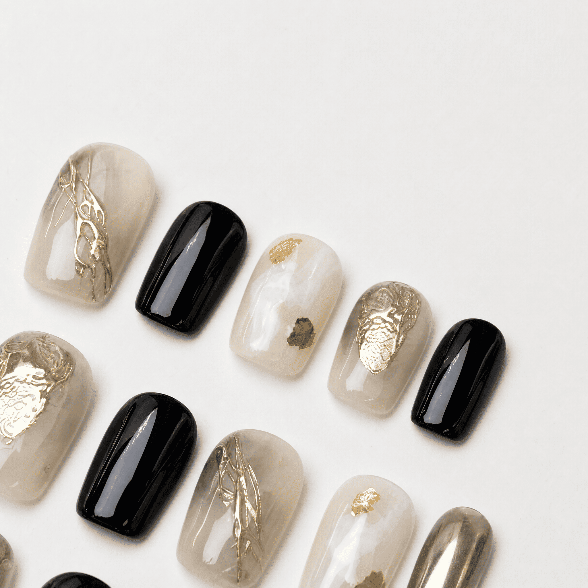 Black and gold short squoval press-on nails with smoky nude accents