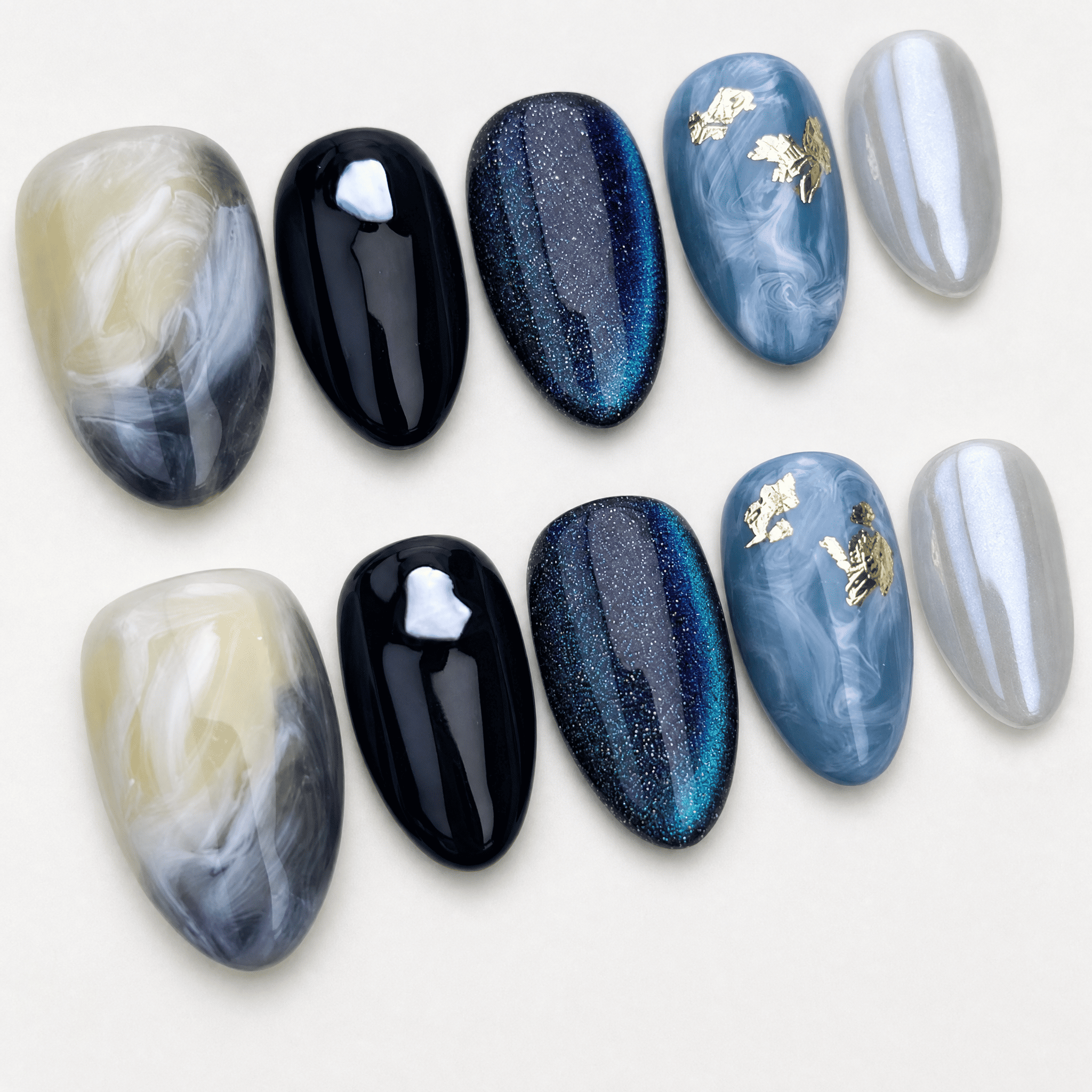 Blue cat-eye short almond press-on nails with black and marble designs