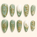 Thirty mint-green almond press-on nails with gold celestial designs