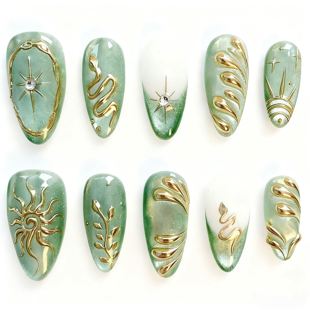 Thirty mint-green almond press-on nails with gold celestial designs
