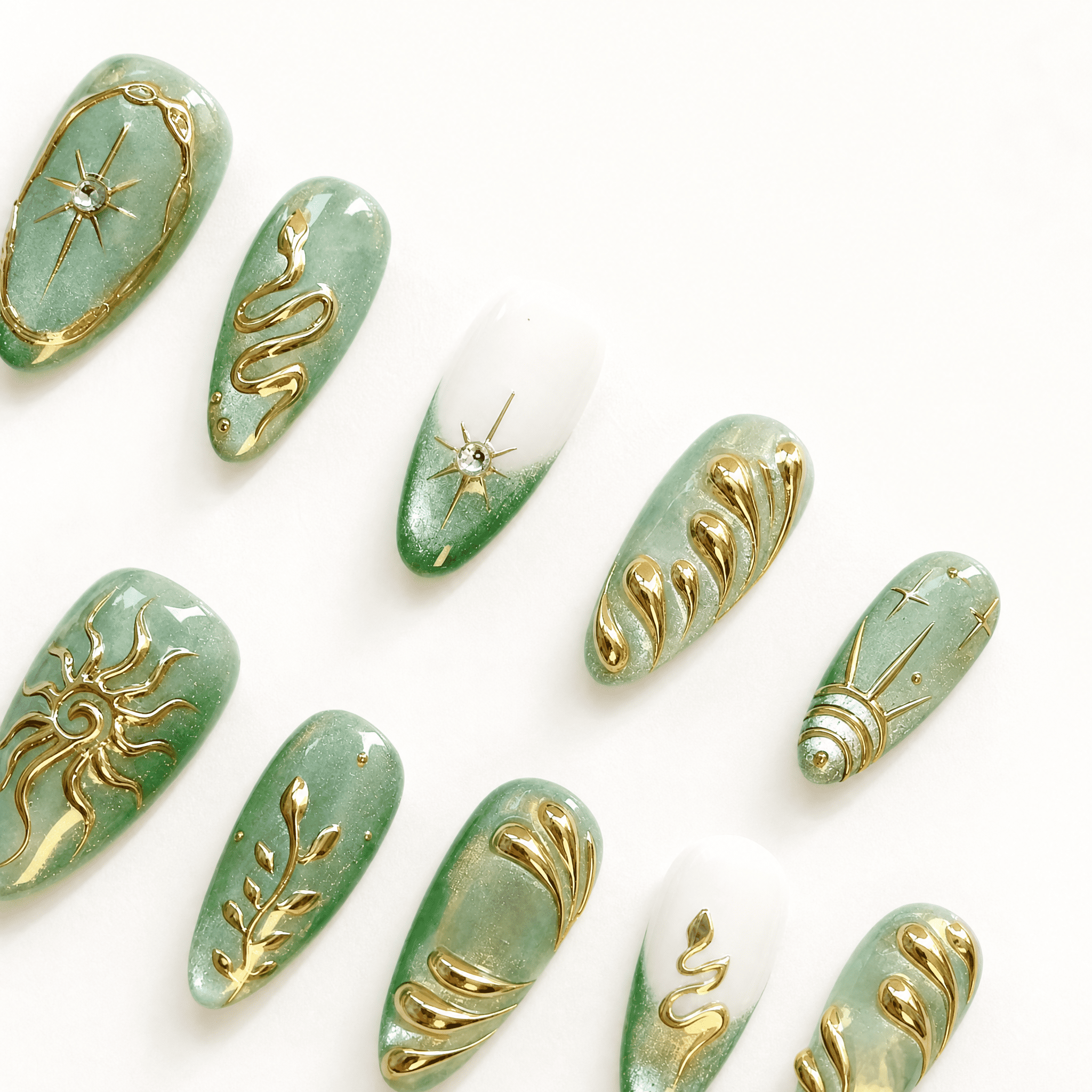 Thirty mint-green almond press-on nails with gold celestial designs
