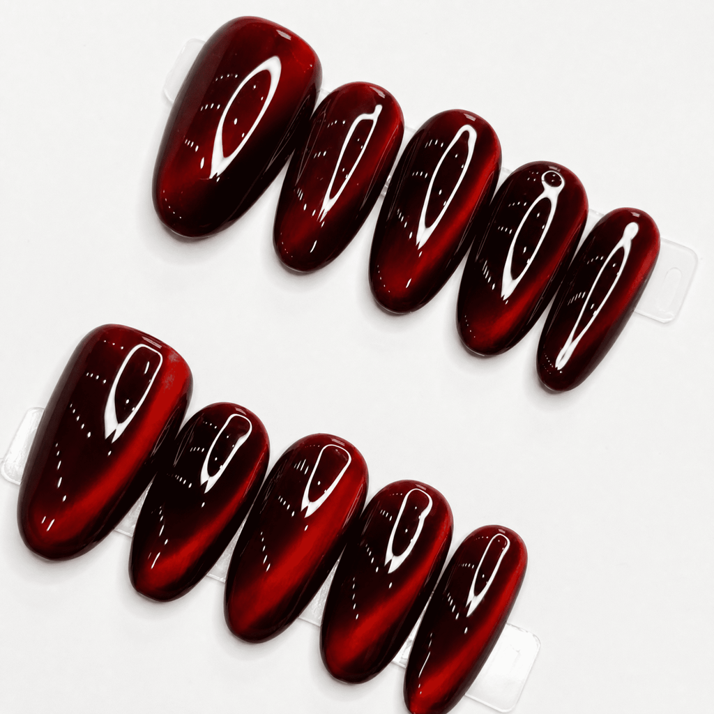 Ruby-red short-oval cat-eye press-on nails with reflective shimmer