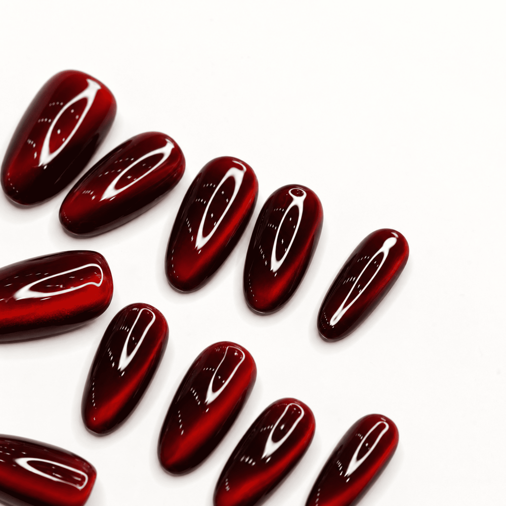 Ruby-red short-oval cat-eye press-on nails with reflective shimmer